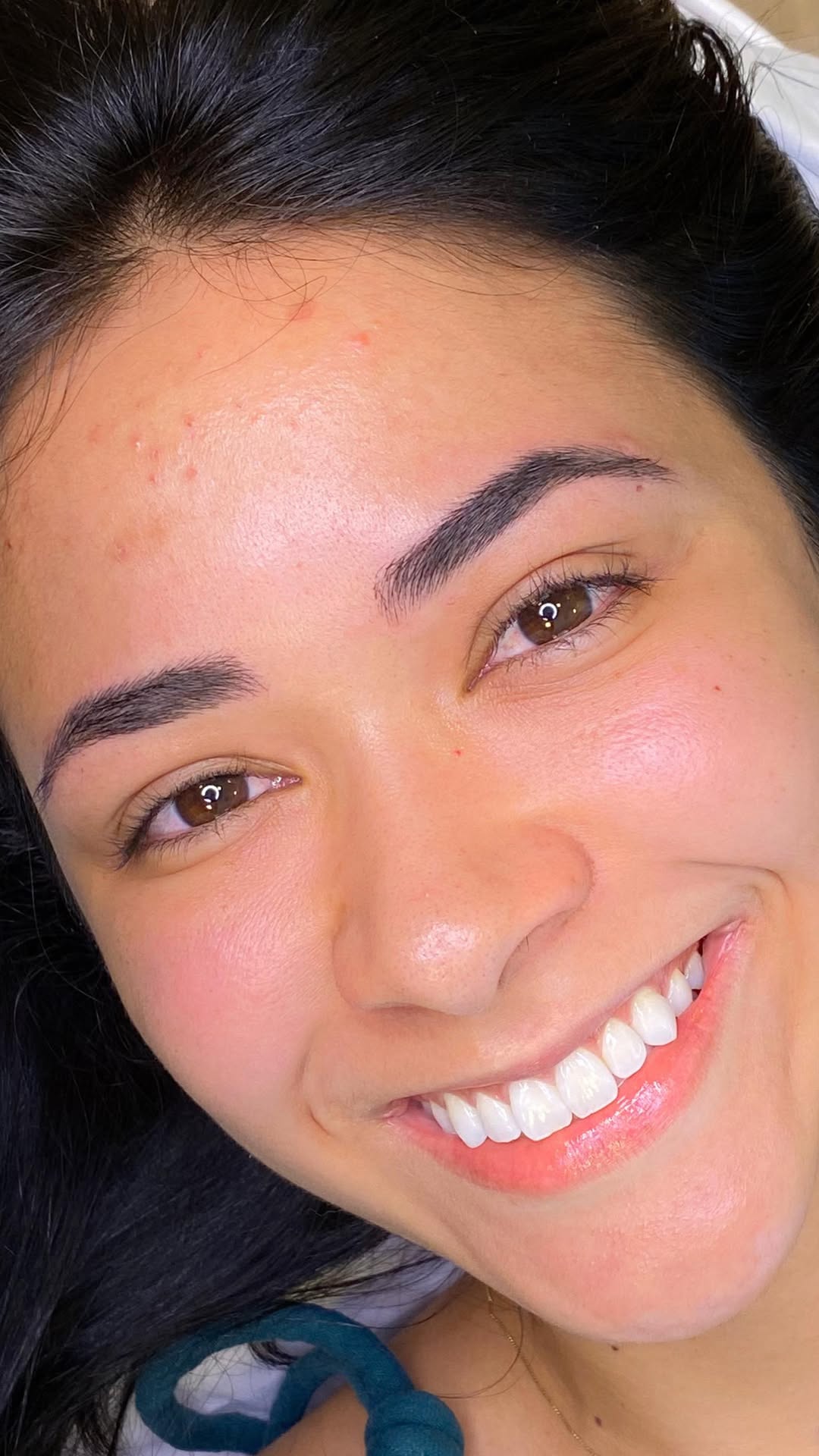 Cliente sorrindo com sobrancelhas recém-desenhadas